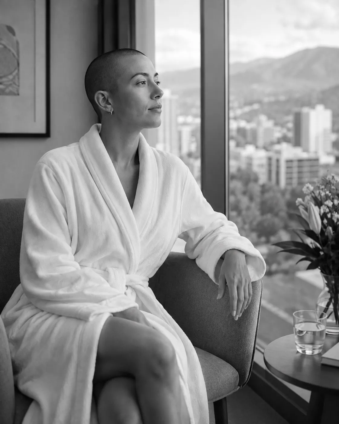A woman in a white robe looking out over a city skyline