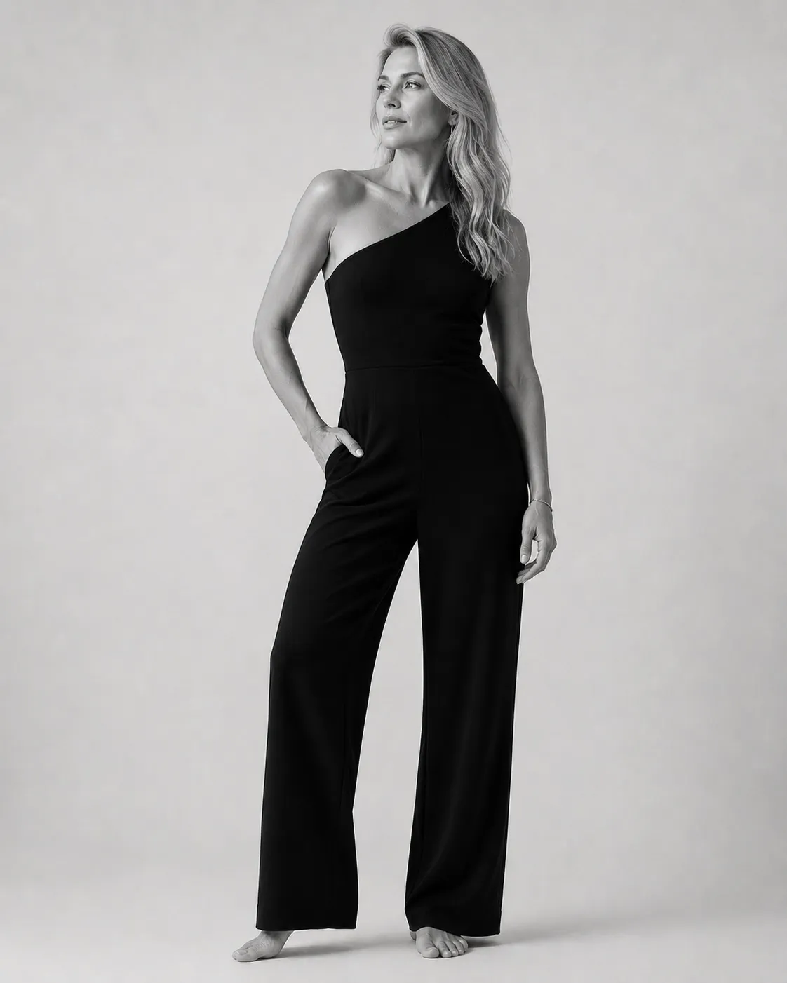 Black and white studio portrait of a woman in a black jumpsuit