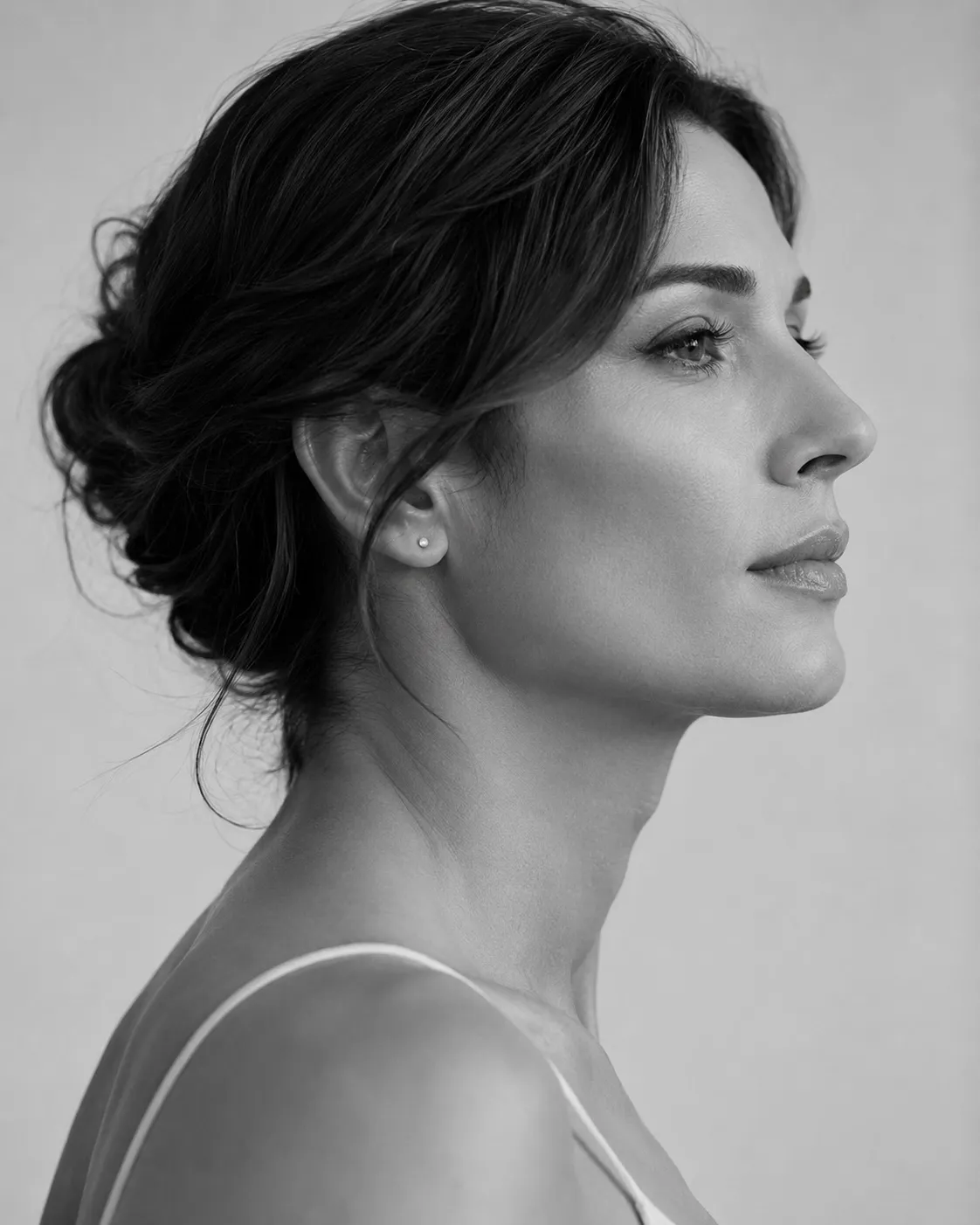 Black and white studio profile portrait of a woman looking upward