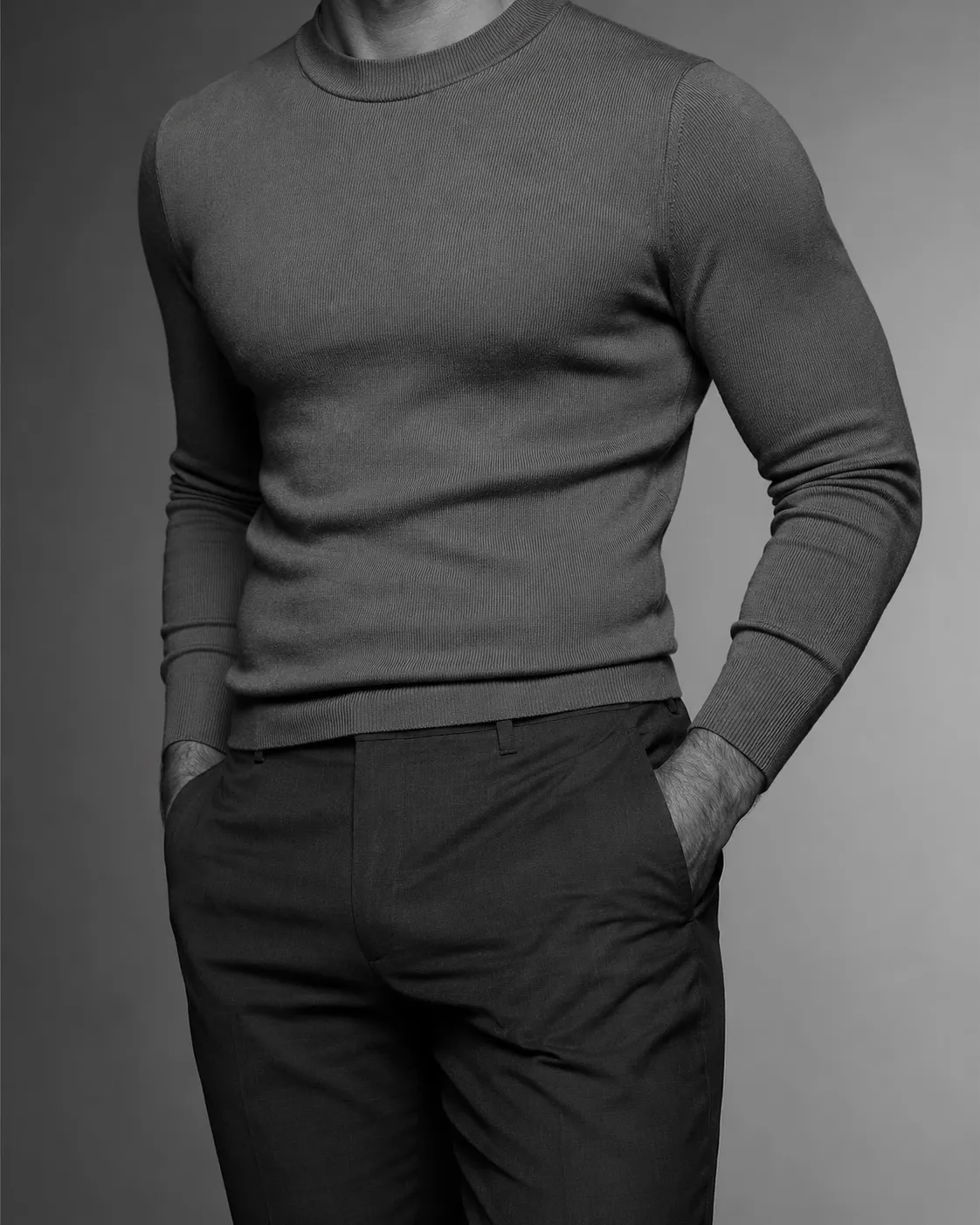 Black and white studio portrait of a man in a fitted knitted top