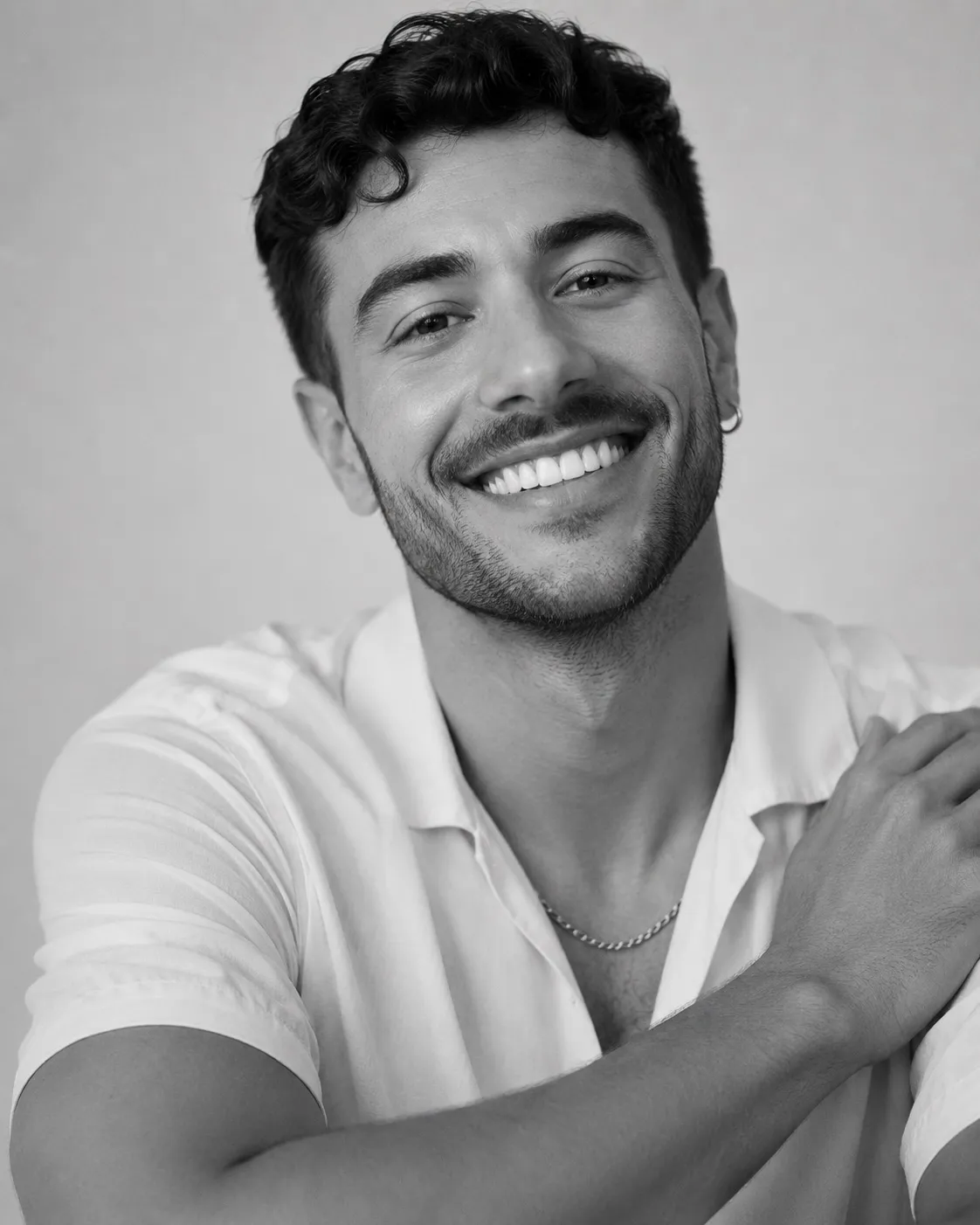 Black and white portrait of a smiling man in a white shirt
